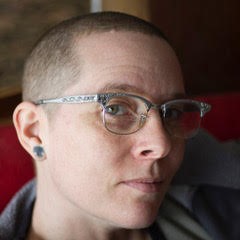 Person in glasses gives sideways glance.