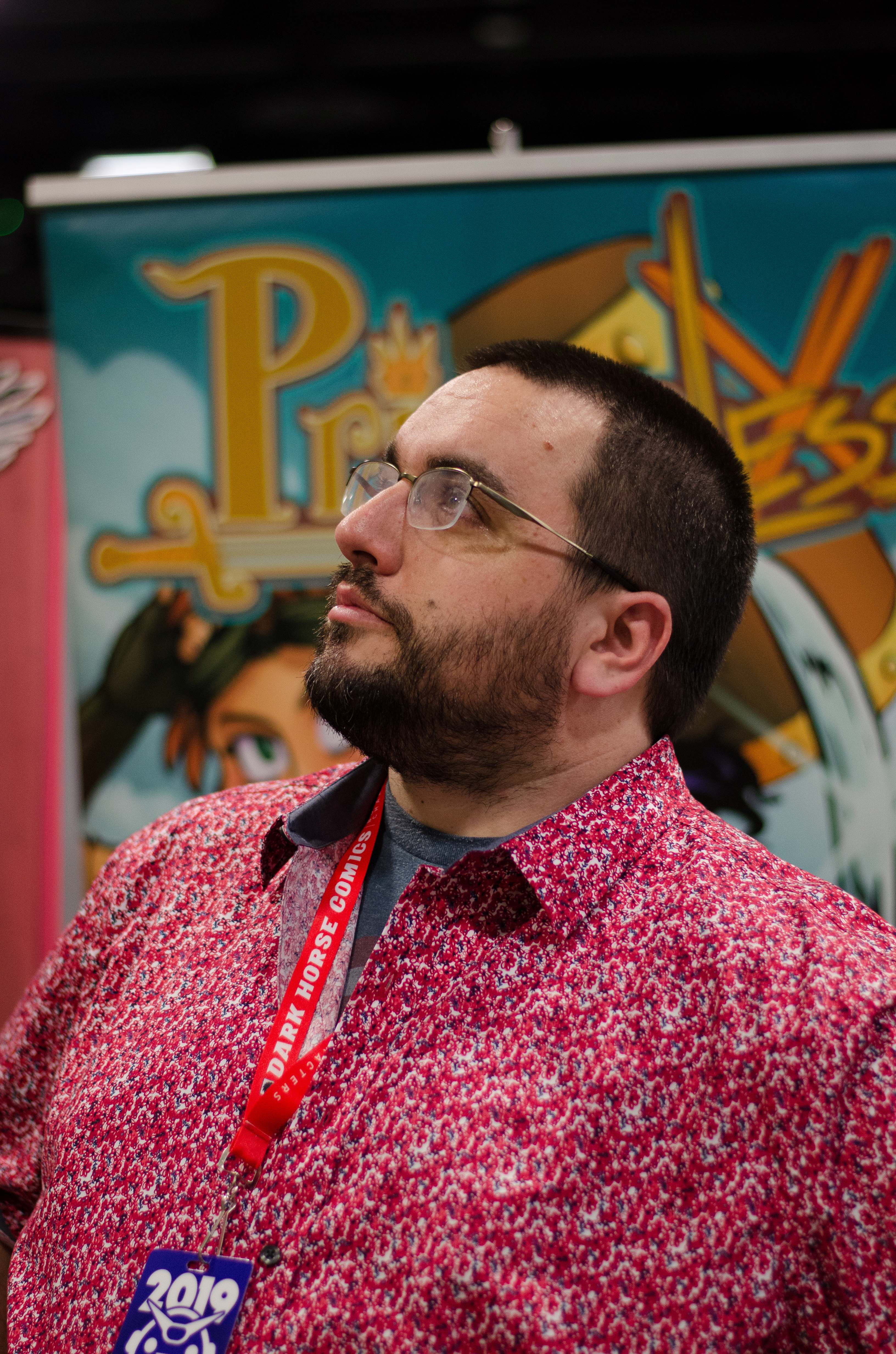 Person with glasses with comic artwork in the background.